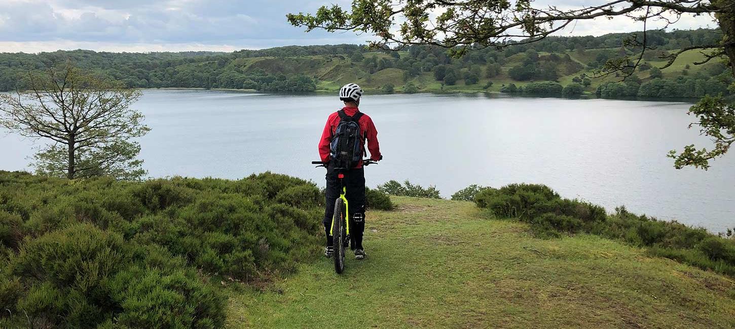 Mountainbiker mit Blick auf einen See