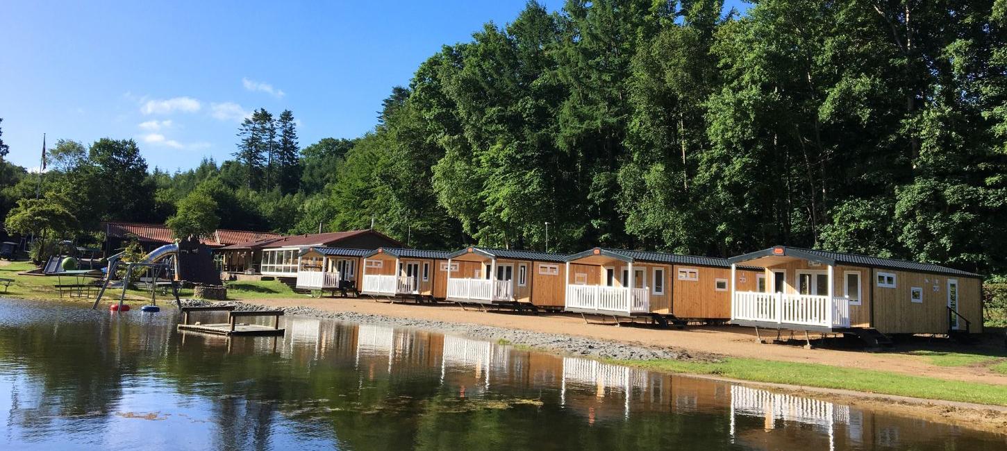 Hütten auf Randbøldal Camping am See an einem Sommertag