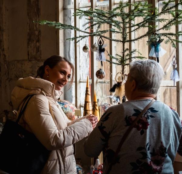 Zwei Personen schauen sich Stände auf dem Weihnachtsmarkt bei Tirsbæk Gods an