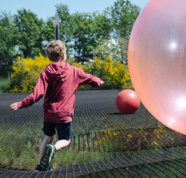 Junge springt im WOW PARK auf großem Trampolin mit großen Bällen