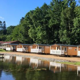 Hütten auf Randbøldal Camping am See an einem Sommertag